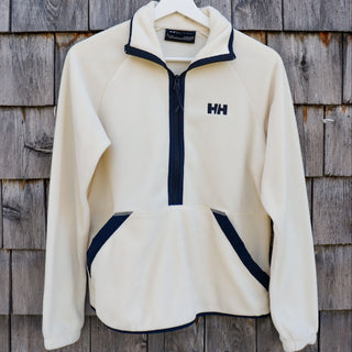 White fleece jacket with navy accents on a wooden background